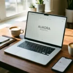 Laptop met professionele website op houten bureau met smartphone, notitieblok en koffie in natuurlijk licht