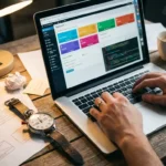 Webontwikkelaar typt op laptop met WordPress dashboard, stopwatch en koffie op houten bureau